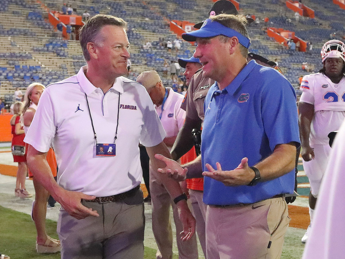 Scott Stricklin talks with Dan Mullen after a Gators win